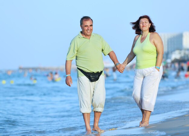 Cheerful couple having some good time naked on the beach